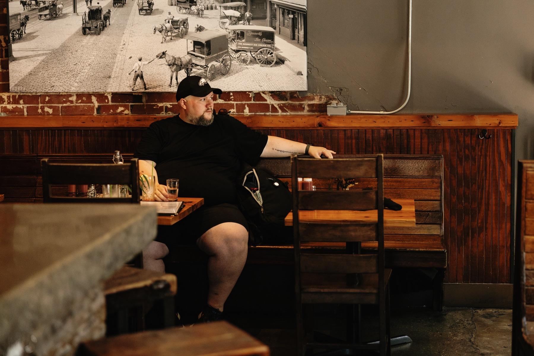 Justin waiting at a table in a South Philadelphia restaurant