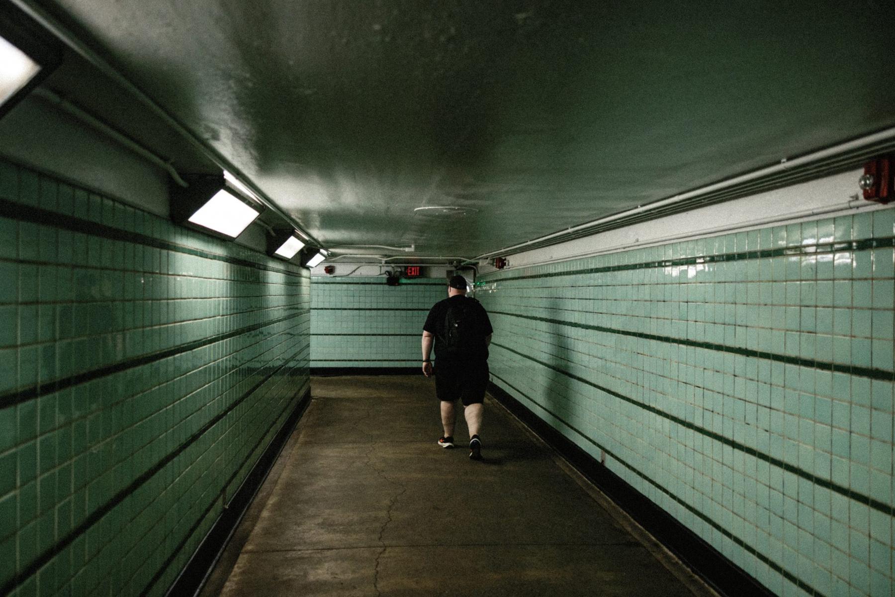 A tiled SEPTA subway corridor in Philadelphia, one person walking away